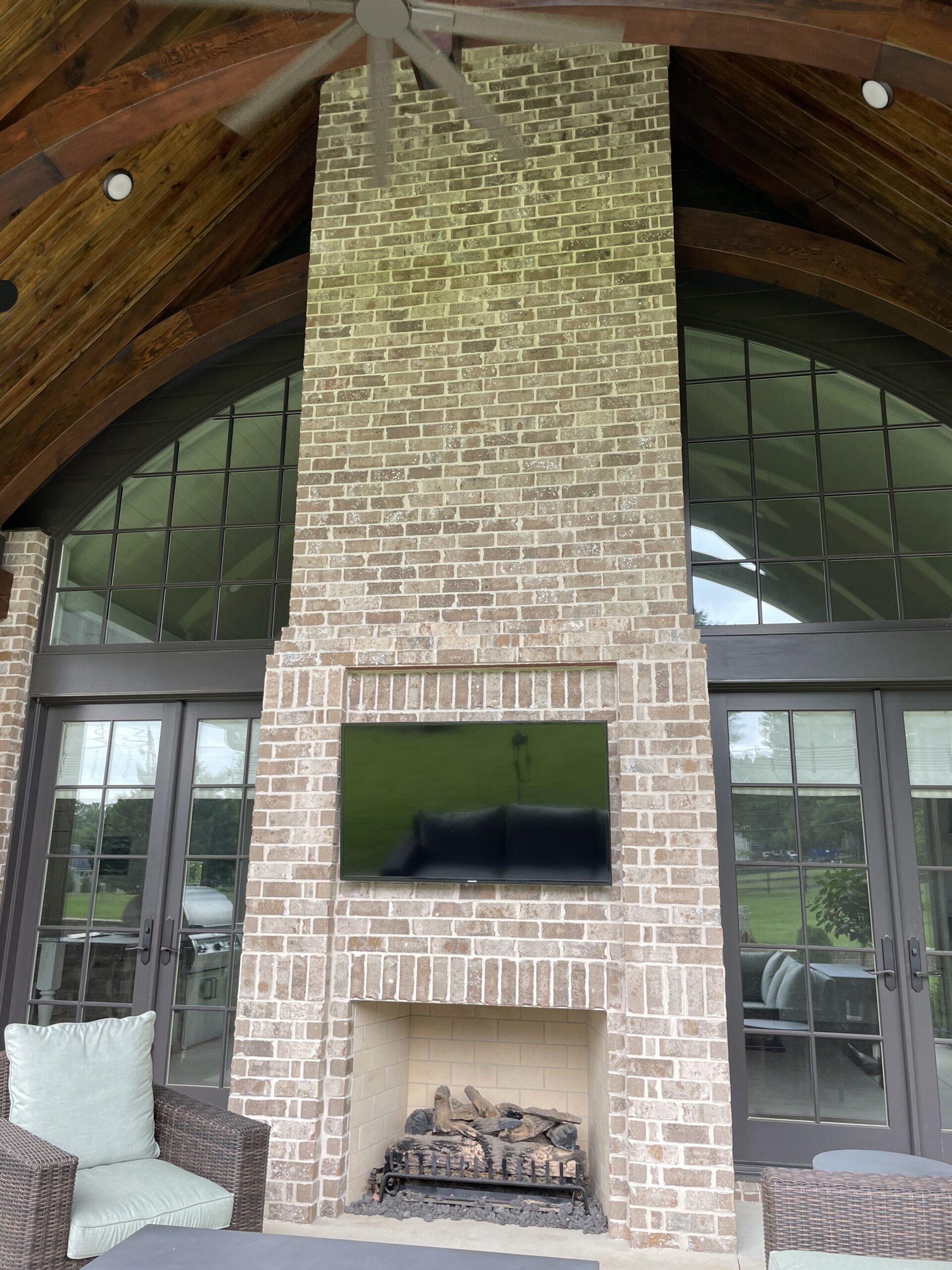 Back patio home improvement in Franklin includes a brand new fireplace and Outside TV from a Brentwood Home Builder